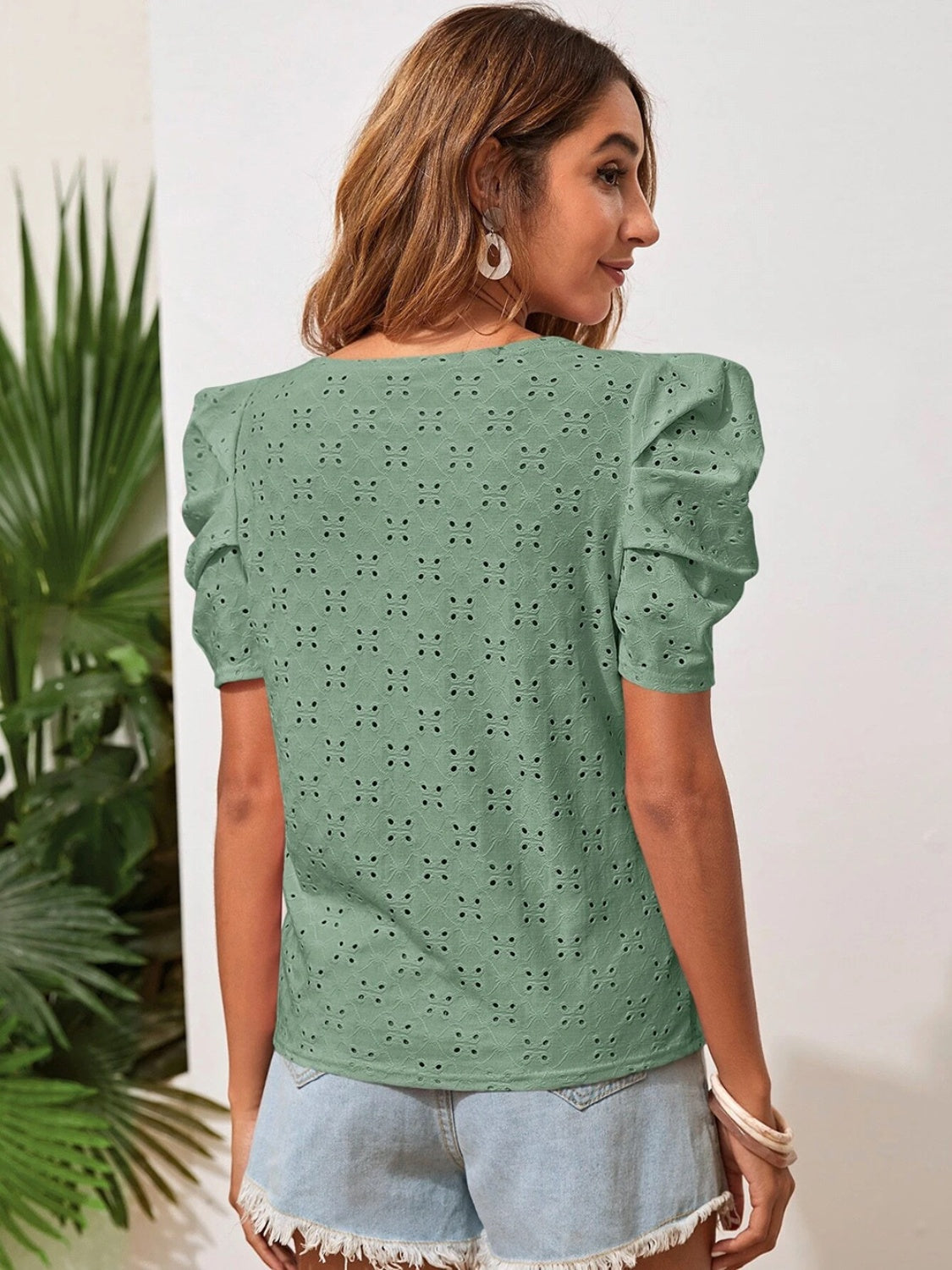 Blusa con mangas abullonadas y cuello redondo con ojales